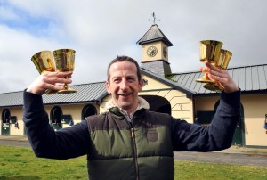 Jim Cullotty, trainer of Cheltenham Gold Cup winner Lord Windermere with his four Gold Cup trophies, three won with Best Mate. Pic: Healy Racing / Racingfotos.com (Courtesy of Great British Racing).