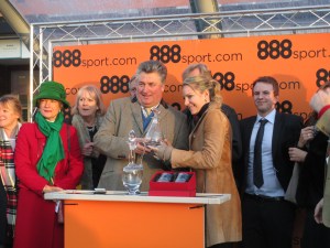 Paul Nicholls receives the trophy after winning the Tingle Creek Chase.